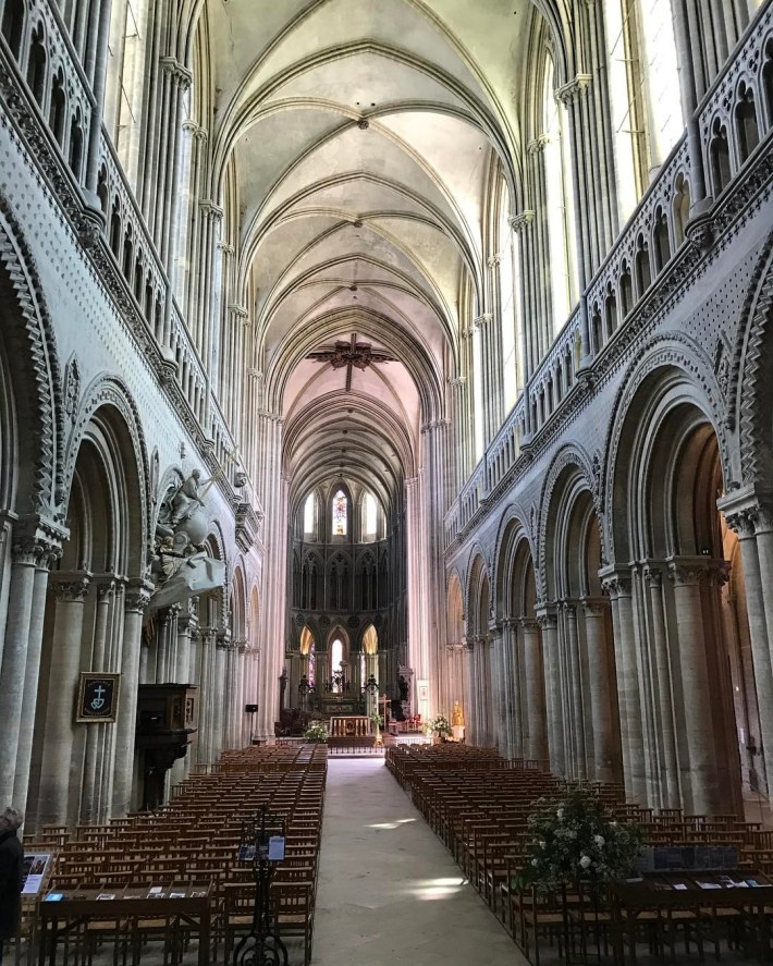 The long, tall nave of Bayeux Cathedral. Columns on either size, arches above.