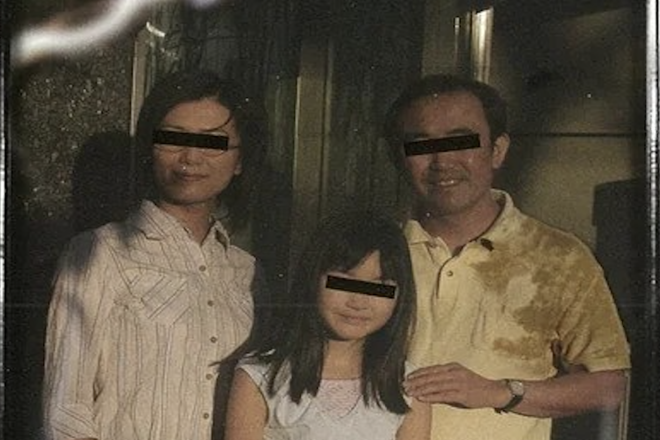 A Japanese mother, father, and daughter pose for the camera. Their eyes are covered with black boxes.