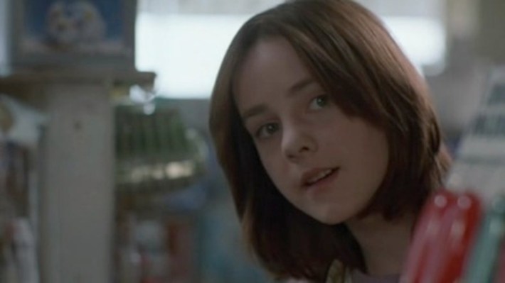 A redhaired girl looks at the camera.