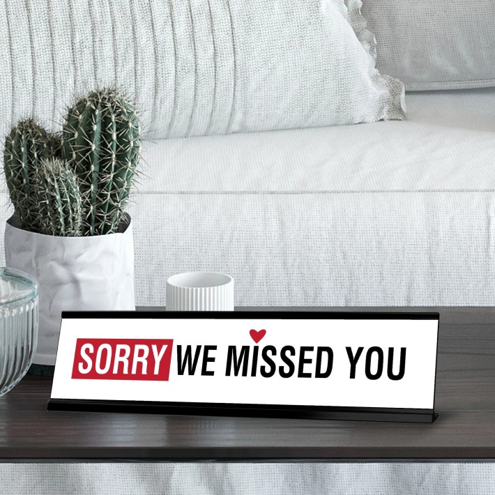 A desk sign reading "SORRY WE MISSED YOU"