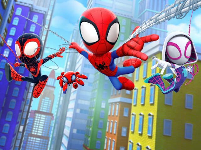 A cute, big headed Spider-Man swings over the city with a version of Spider-Man in black and red, a version in a white hoodie, and a robot spider.