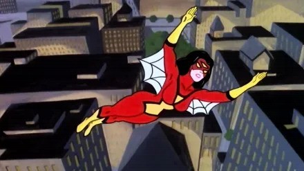 A woman in red, with a mask and web wings under her arms, flies above a city.