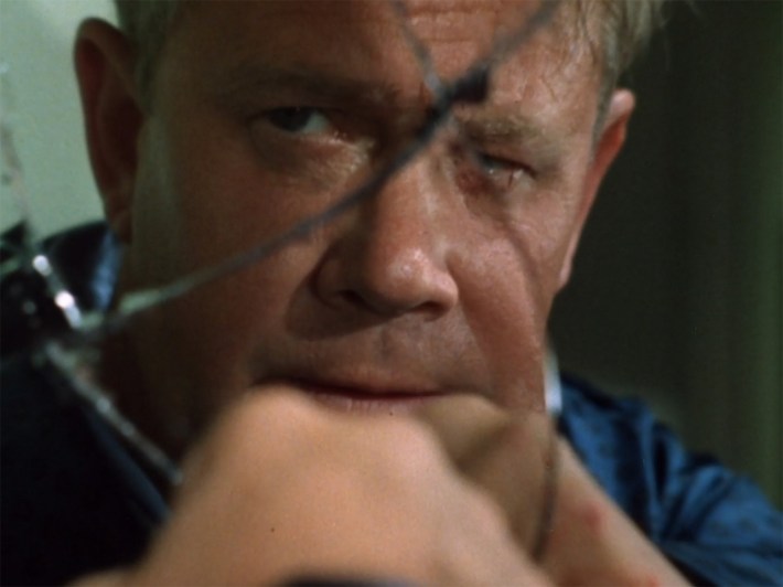 Colonel Six looking in broken mirror