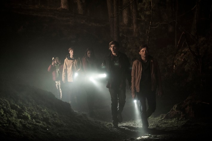 Teens in woods with flashlights