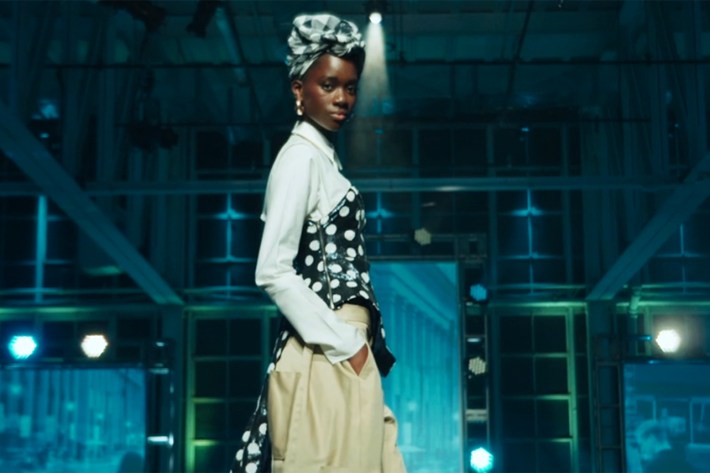 Model in white shirt, khakis, with sequin corset