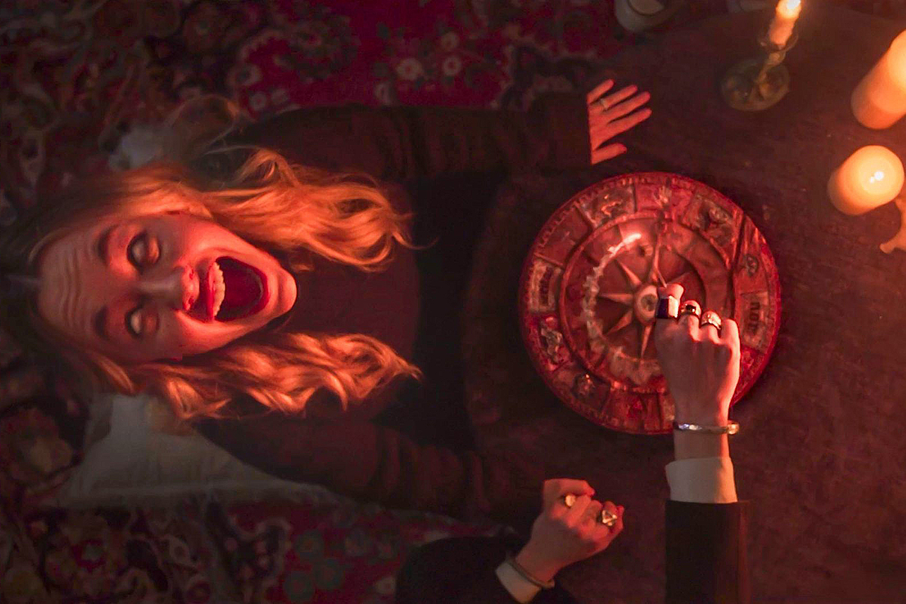 Woman at witchboard with candles