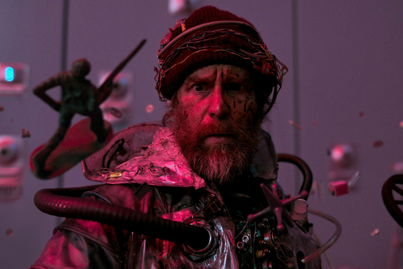 Sam Rockwell with beard in weird homemade tech jumpsuit thing