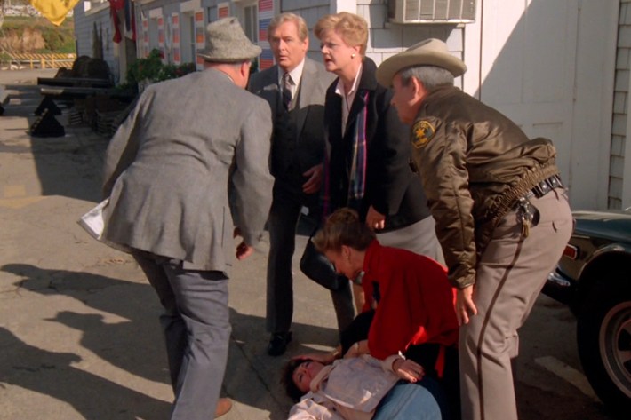 People crowding around dead body