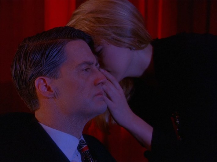 Laura whispering in Coop's ear