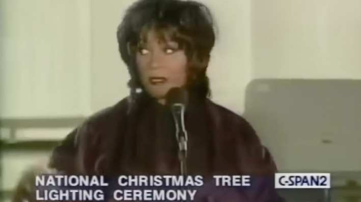 A woman behind a microphone rolls her eyes.