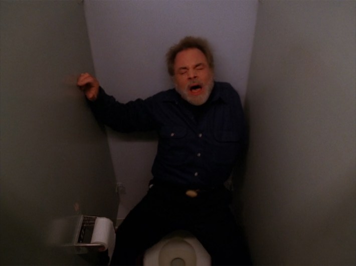 One armed man in bathroom stall