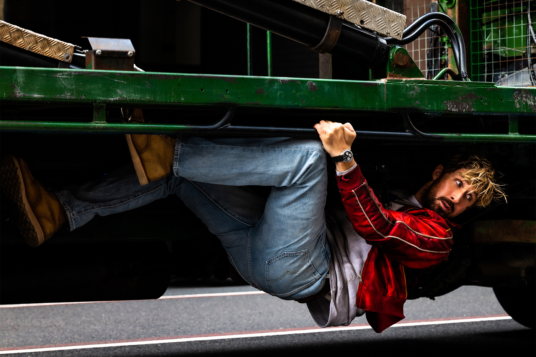 Ryan Gosling on bottom of moving vehicle
