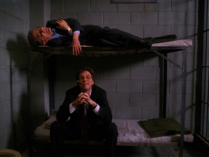 Men in suits on bunk beds in prison