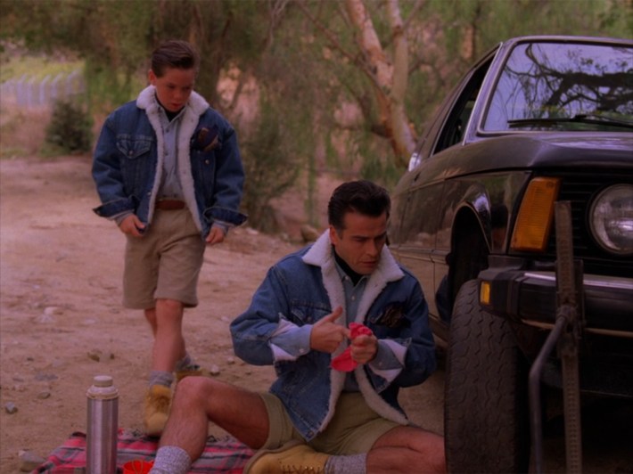 Two people in matching shearling jackets and shorts