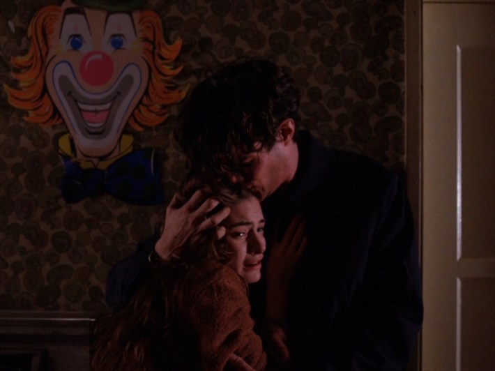 People hugging under clown