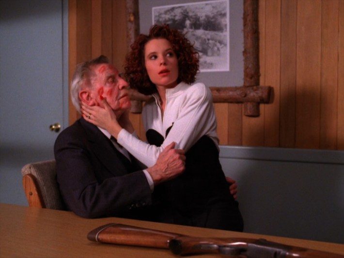 Woman on lap of man with kisses on his face