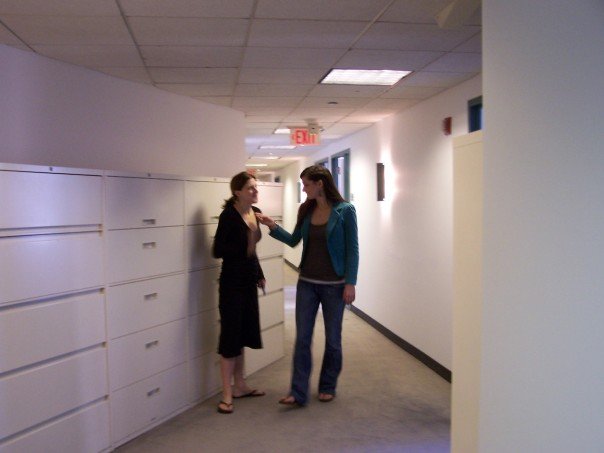 two people standing in front of large filing cabinets