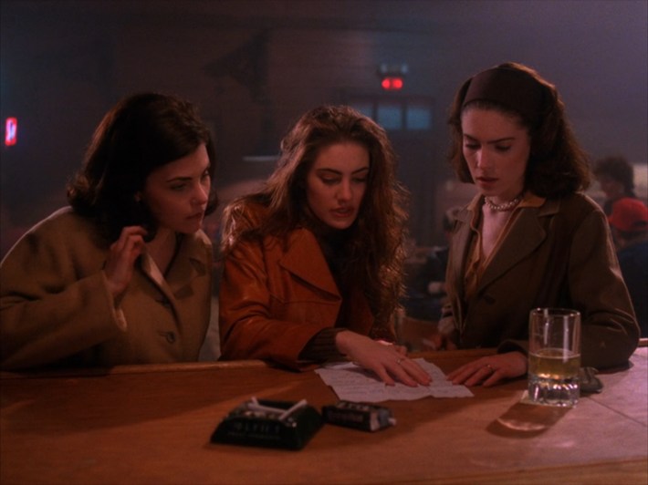 Three women at bar with pieces of note