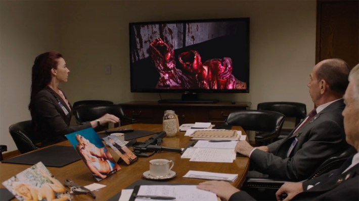 FBI agents looking at TV with bloody bodies on it