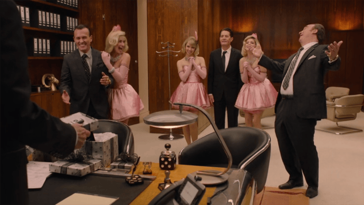 Men in suits and women in pink cocktail dresses